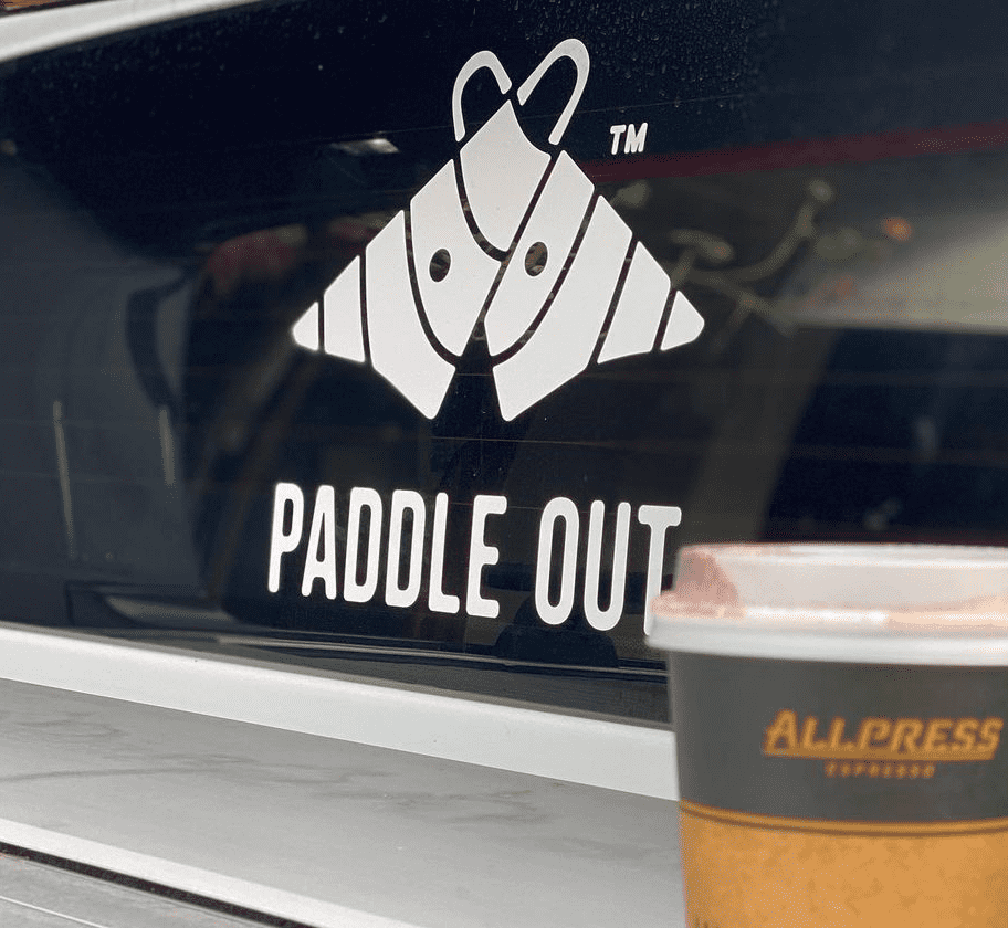 Paddle Out logo white lettering decal on pick up truck rear windshield.