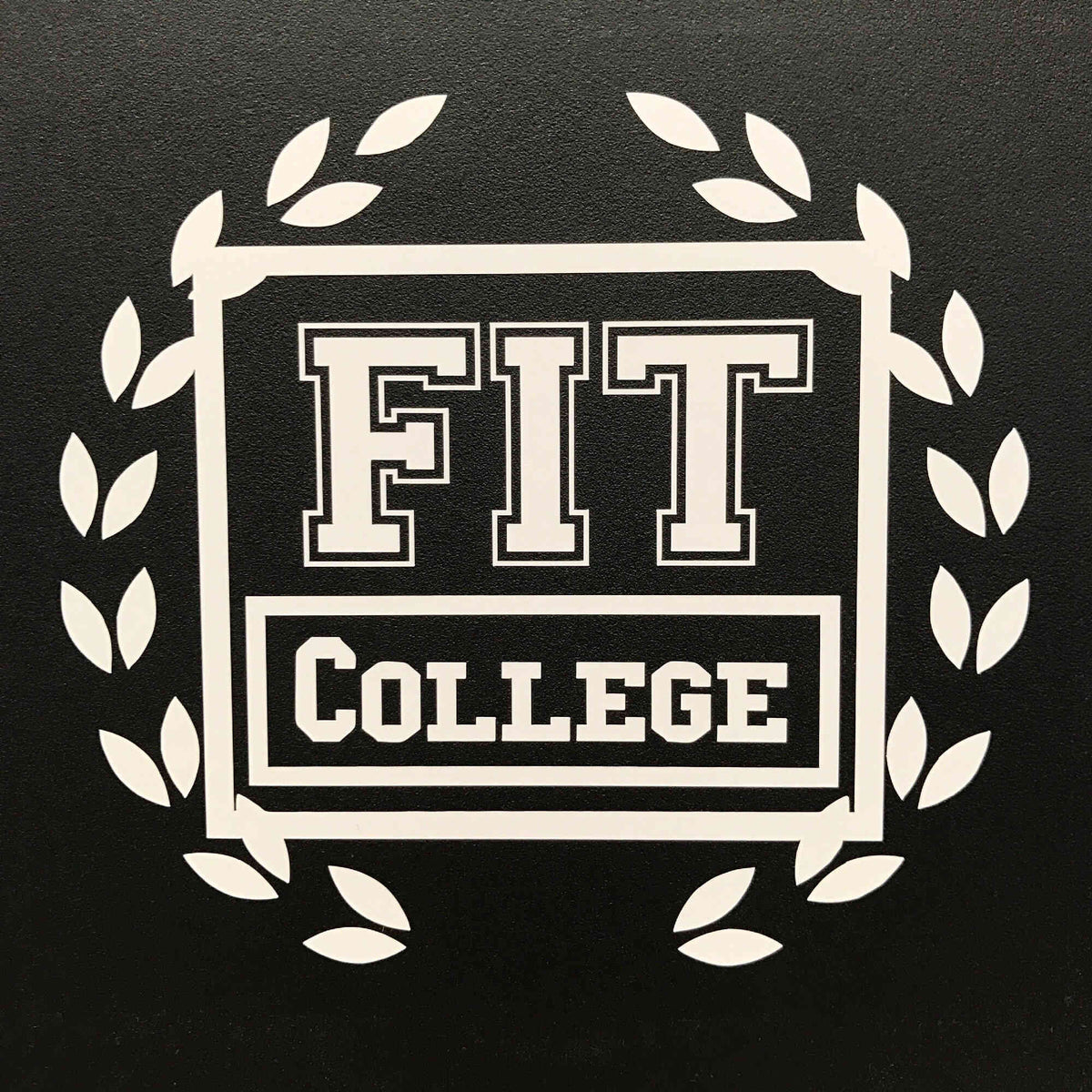 White FIT College lettering logo with wreath decal on black surface.